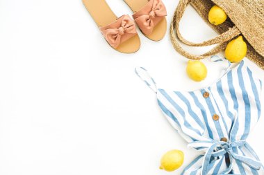 Yaz kadın moda şık kompozisyon. Giysi, terlik, saman, Lale çiçek, beyaz zemin üzerine limon. Yat, üstten görünüm giyim ve aksesuarları kolaj.