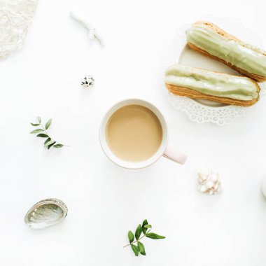 Kahve kupa, fıstıklı kek, yaprakları ve beyaz arka plan üzerinde deniz kabukları ile kahvaltı kavramı. Gıda kompozisyon tarz düz yatıyordu, en iyi görünümü.