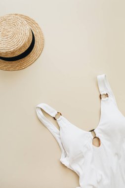 Düz yatıyordu yaz moda kompozisyon. Bayan mayo, pastel bej renkli arka plan üzerinde saman. Düz yatıyordu, en iyi görünüm çok az beach kavramı.