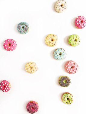 Beyaz arka plan üzerinde renkli çörekler. Düz yatıyordu, en iyi görünüm çok az desen.