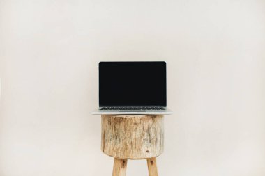 Ahşap dışkı üzerinde önden görünüm laptop. Yaşam tarzı blog kahraman başlığı. Yaratıcı blog ya da sosyal medya arka plan. Yukarı alay.