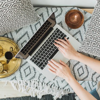 Genç kadın yatakta dizüstü bilgisayarda yazarak. Yaşam tarzı kahraman başlığı yukarıdan manzaralı. Serbest meslek ya da moda blogger ev çalışma alanı kavramı.