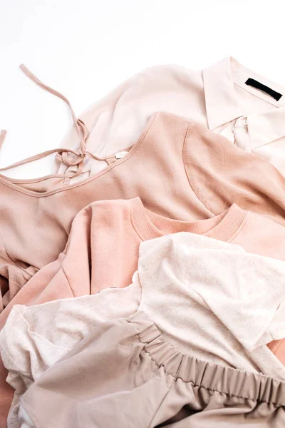 Female pale pastel pink clothes. Flat lay, top view fashion concept.