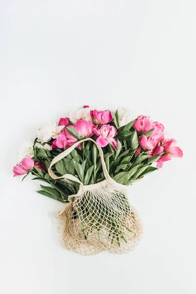 ひも付きの袋の白い背景で隔離のピンクと白の牡丹の花 フラット横たわっていた トップ ビュー最小限花コンセプト — ストック写真