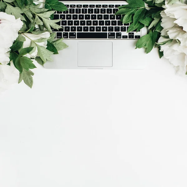 Beyaz arka plan üzerinde laptop ve beyaz peonies çiçekli düz yatıyordu, en iyi görünüm kompozisyon. Blog kahraman başlığı.