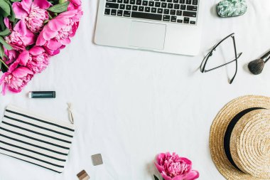 Kadın ofis büro dizüstü, pembe peony çiçek buketi, Gözlük, hasır şapka, kozmetik ile düz yatıyordu, en iyi görünümü çerçeve. Moda ya da güzellik blog arka plan.