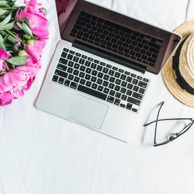 Düz yatıyordu, en iyi kadın ofis resepsiyon çalışma alanı görüntüle laptop, pembe peony çiçek buketi, Gözlük, beyaz arka plan üzerinde hasır şapka ile. Moda blog kadar sahte.