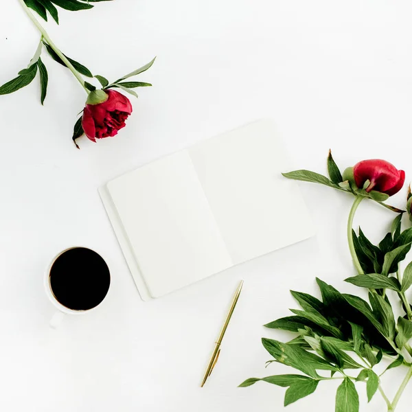 Minimal home office desk with blank notebook, coffee and peony flowers on white background. Flat lay, top view mock up.