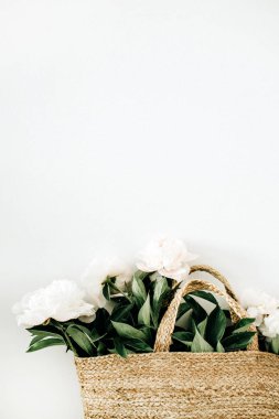 Hasır çanta beyaz arka plan üzerinde beyaz şakayık çiçekleri ile. Düz yatıyordu, en iyi görünümü.