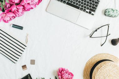 Dizüstü bilgisayar, pembe peony çiçek buketi, Gözlük, hasır şapka, beyaz arka plan üzerinde kozmetik ile kadın ofis resepsiyon çalışma alanının düz yatıyordu, en iyi görünümü çerçeve. Moda ya da güzellik blog kavramı.