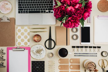 Düz yatıyordu, en iyi görünümü yaratıcı ofis resepsiyon kolaj. Pembe peonies çiçek buketi, laptop, cep telefonu, pano, Etiketler, bej renkli arka plan üzerinde aksesuarları ile kadın sanatsal çalışma alanı. Çiçekçi, serbest meslek sahibi veya blogger kahraman başlığı.