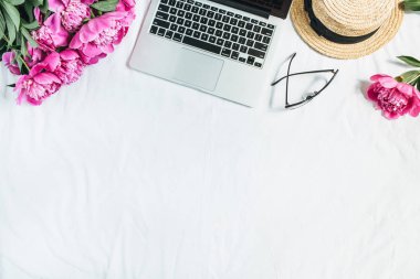 Düz yatıyordu, en iyi kadın ofis resepsiyon çalışma alanı görüntüle laptop, pembe peony çiçek buketi, Gözlük, beyaz arka plan üzerinde hasır şapka ile. Moda blog kahraman üstbilgi şablonu.