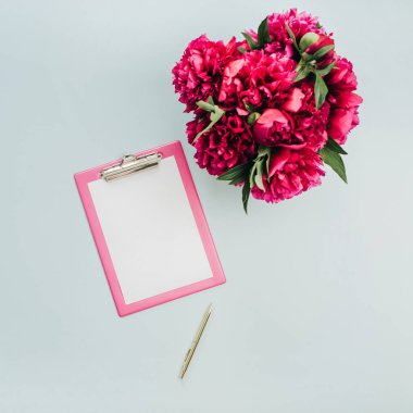 Minimalist düz ofis tablo masası Pano, pembe peony çiçek buketi mavi zemin üzerine yatırın. Üstten görünüm iş kavramı kadar sahte.