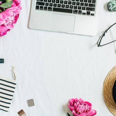 Kadın ofis büro dizüstü, pembe peony çiçek buketi, Gözlük, hasır şapka, kozmetik ile düz yatıyordu, en iyi görünümü çerçeve. Moda ya da güzellik blog arka plan.