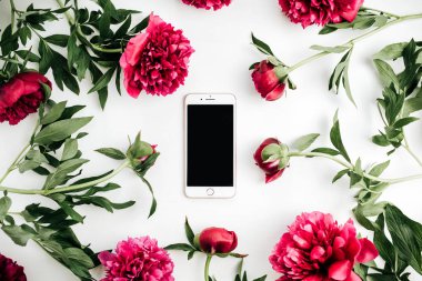Hareket eden telefon içinde pembe peonies çiçek beyaz zemin üzerine çerçeve. Düz yatıyordu, en iyi görünümü kadar sahte.