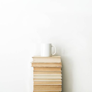 Books pile and coffee mug on white background. Minimal education concept. clipart