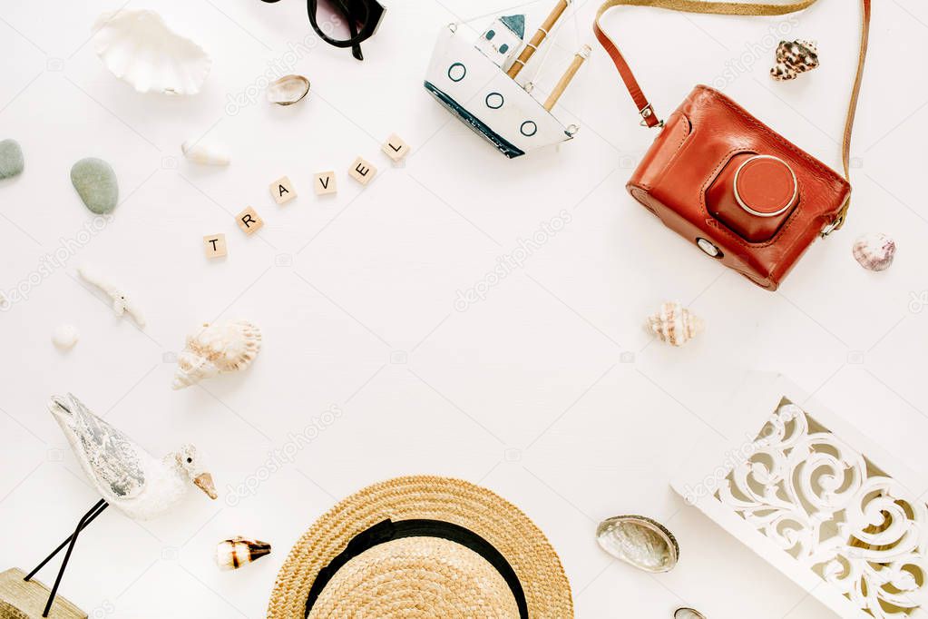 Round frame of travel composition with straw hat, retro camera, bird sculpture, toy boat, seashells on white background. Flat lay, top view traveler blog mock up.