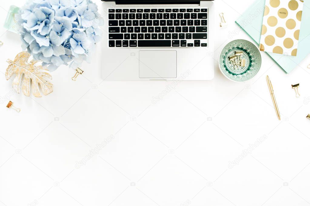 Home office desk workspace with laptop, hydrangea flowers bouquet, accessories on white background. Flat lay, top view blog hero header.