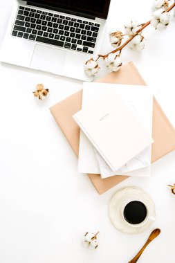 Laptop, defter, kahve fincanı, beyaz zemin üzerine pamuk şube ile modern ev ofis masası. Düz yatıyordu, en iyi görünüm çok az çalışma alanı.