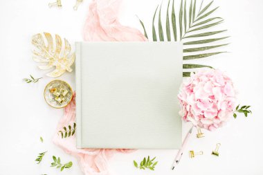 Düğün veya aile fotoğraf albümü, ortanca çiçek buketi, tropikal palmiye yaprağı, pastel pembe battaniye, beyaz zemin üzerine altın monstera plaka ile kompozisyon. Düz yatıyordu, en iyi görünümü natürmort kavramı.