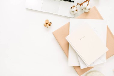 Kadın çalışma alanıyla laptop, defter, pamuk şube beyaz arka plan üzerinde. Düz yatıyordu, en iyi görünüm çok az ev ofis masası.