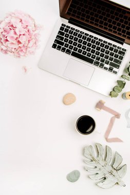 Ev ofis büro dizüstü bilgisayar, pembe ortanca çiçek buketi, kahve fincanı, okaliptüs şube, monstera yaprak plaka ve aksesuar beyaz arka plan üzerinde. Düz yatıyordu, en iyi görünümü.