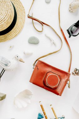 Kuş heykelcik, oyuncak tekne, retro kamera, güneş gözlüğü, kabukları ve beyaz arka plan üzerinde hasır şapka ile yaratıcı kompozisyon. Düz yatıyordu, en iyi görünümü yaşam tarzı blog kavramı.