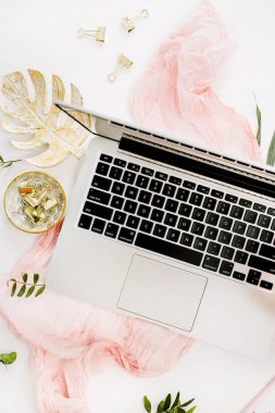 Kadın ev ofis büro dizüstü bilgisayar, pembe ortanca çiçek buketi, pastel battaniye, monstera yaprak plaka ve aksesuar beyaz arka plan üzerinde. Altın çalışma alanı düz yatıyordu, en iyi görünümü gül.