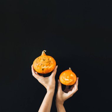 Kadın el Halloween pumpkins siyah arka plan üzerine tutun. En az şenlikli kavramı.