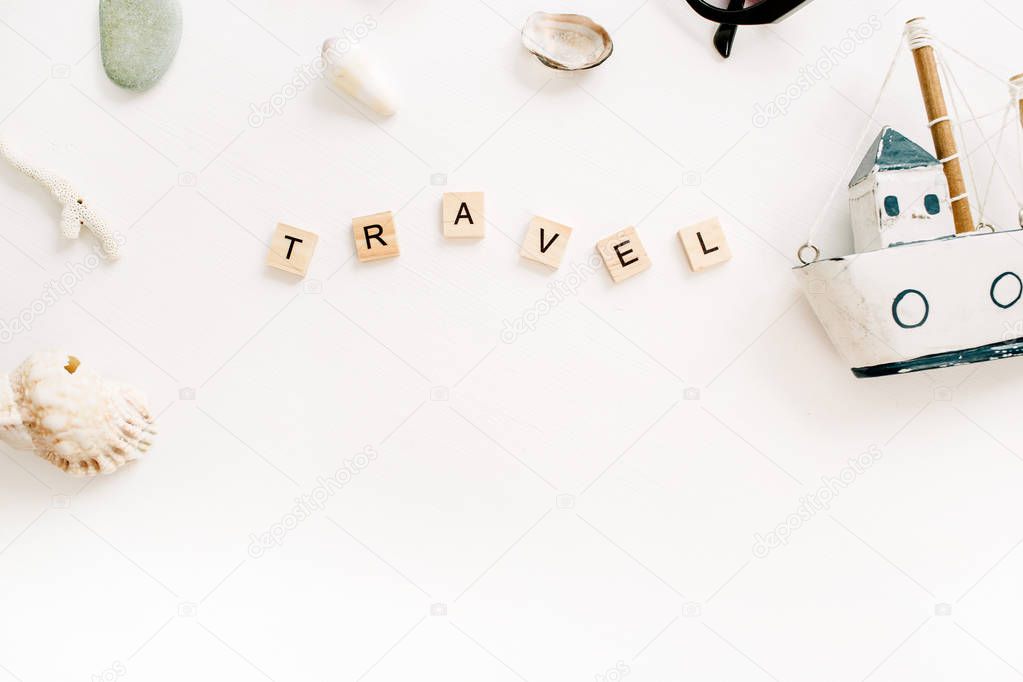 Travel composition with toy boat, seashells on white background. Flat lay, top view.