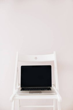 Laptop ekran masaüstü kadar boş sahte ile önden görünüm beyaz sandalye.