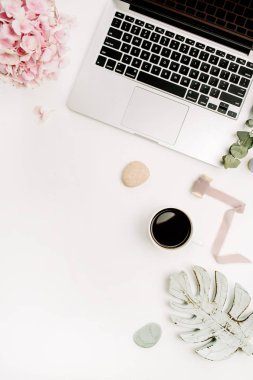 Modern ev ofis resepsiyon çalışma alanı dizüstü bilgisayar, pembe ortanca çiçek buketi, kahve fincanı, okaliptüs şube, monstera yaprak plaka ve aksesuar beyaz arka plan üzerinde. Düz yatıyordu, en iyi görünümü.