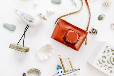 Kuş heykelcik, Oyuncak bot, retro kamera, beyaz arka plan üzerinde kabukları ile modern kompozisyon. Düz yatıyordu, en iyi görünümü Seyahat fotoğrafçı kavramı.