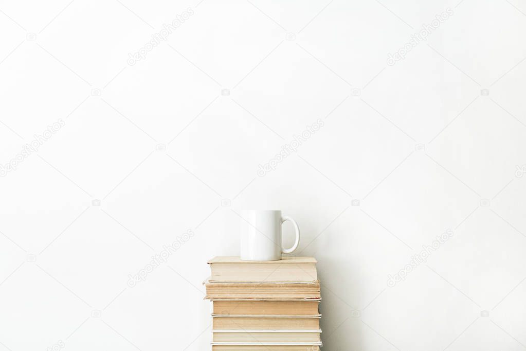 Books and coffee mug on white background. Minimal school concept.