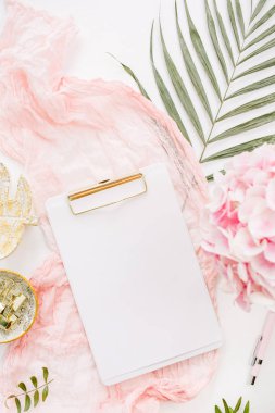 Boş kağıt Pano, pembe ortanca çiçek buketi, tropikal palmiye yaprağı, pastel battaniye, monstera yaprak tabak ve aksesuar beyaz arka plan üzerinde. Düz yatıyordu, en iyi görünümü gül altın ev ofis resepsiyon çalışma alanı mockup.