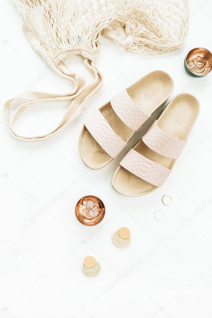 Woman accessories: slippers, string bag, earring and rings on white background. Flat lay, top view fashion accessories.