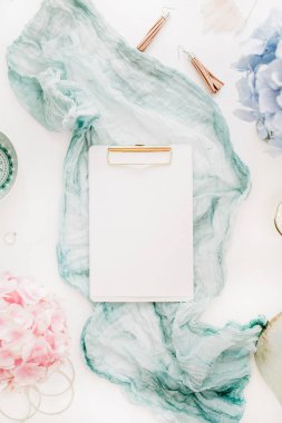 Ev ofis masası clipboard ile kopya alanı, Turkuaz battaniye, pastel renkli ortanca çiçek buketi, kadın moda aksesuar beyaz arka plan üzerinde bulunmaktadır. Düz yatıyordu, en iyi görünümü çalışma alanı mockup.