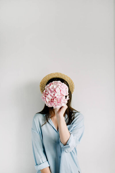 Young woman hold pink hydrangea flower bouquet on white background. Floral beauty fashion concept.