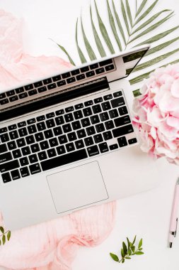 Kadın ev ofis resepsiyon çalışma dizüstü bilgisayar, pembe ortanca çiçek buketi, pastel battaniye, monstera yaprak plaka ve aksesuar beyaz arka plan üzerinde. Düz yatıyordu, en iyi görünümü.