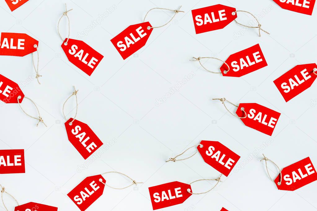 Black Friday sales discount composition. Round frame of red tags with word SALE on white background. Mock up. Flat lay, top view.