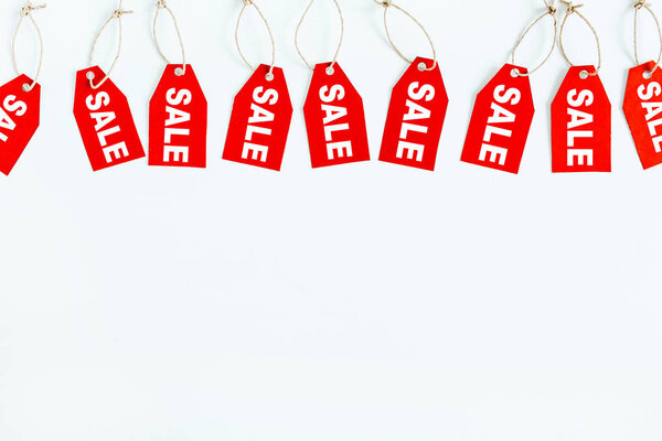 Состав скидок на распродажи "черной пятницы". Красные бирки со словом SALE на белом фоне. Плоский, вид сверху
.