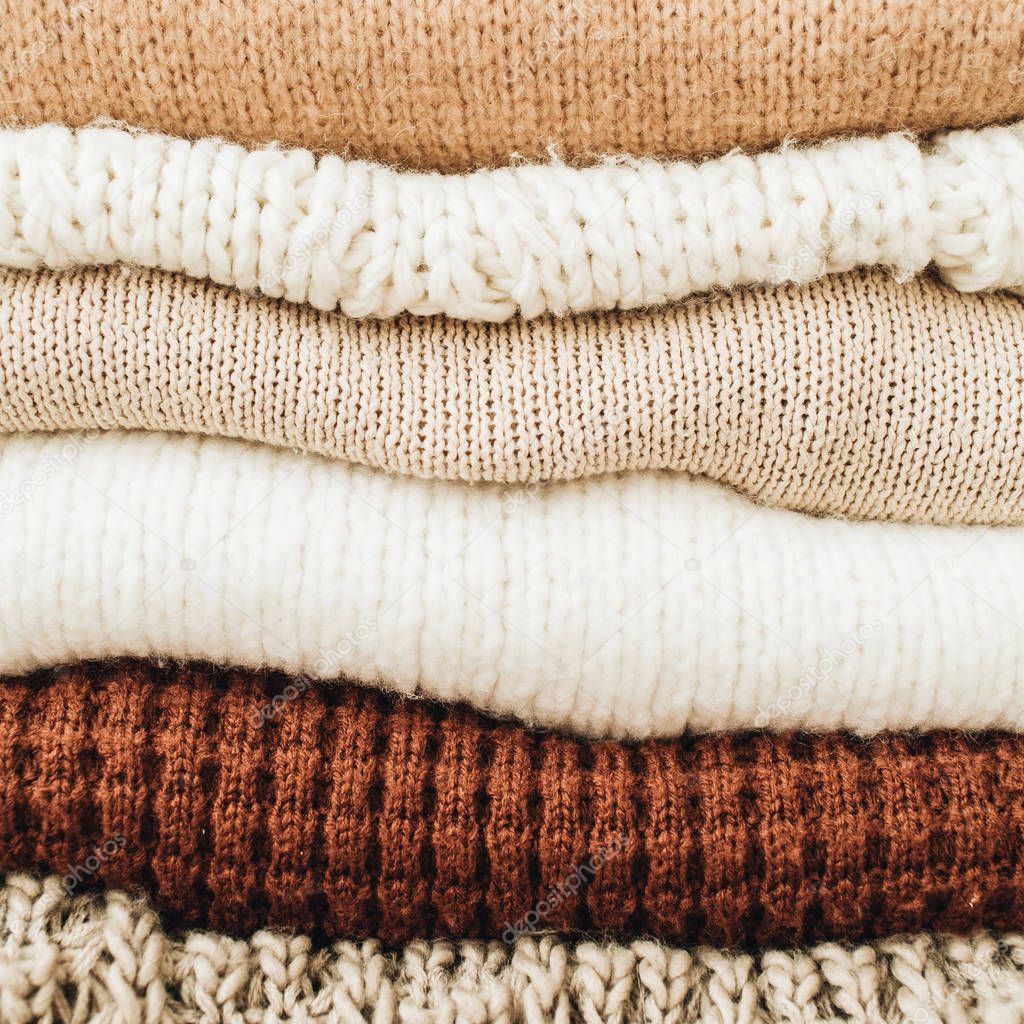 Closeup of warm winter sweaters and pullovers. Female minimal fashion clothes pattern.