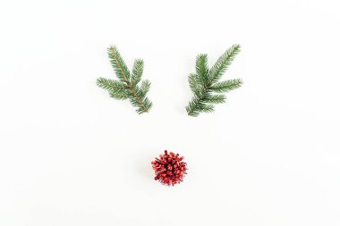 Noel, yeni yıl en az kavramı. Köknar şube ve beyaz arka plan üzerinde izole kırmızı dekorasyon Noel geyiği sembolü yaptı. Düz yatıyordu, en iyi görünümü.