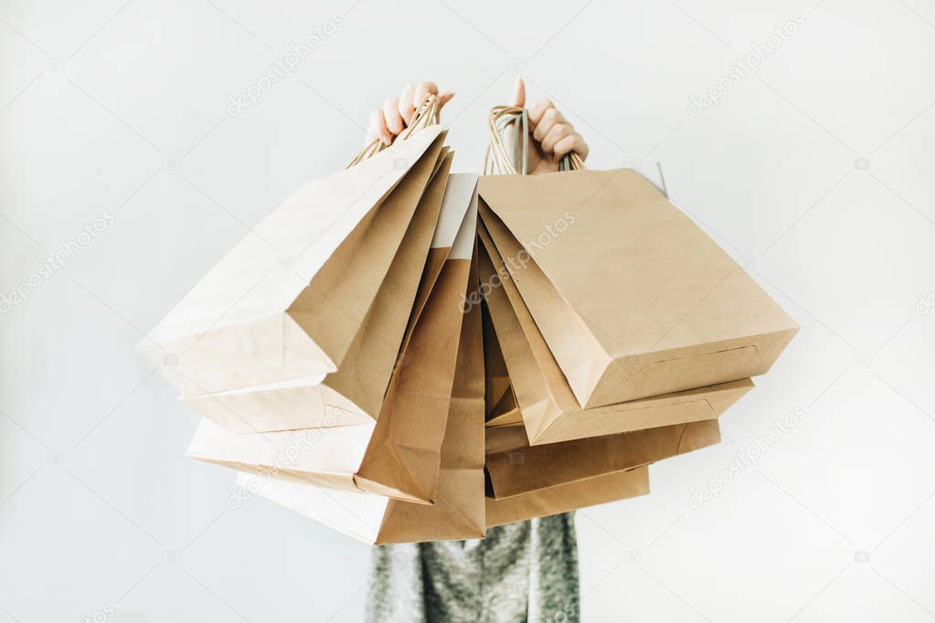 Black Friday sales discount concept. Young woman hold craft paper bags with word Sale on white background.