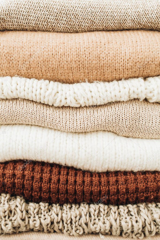 Closeup of warm winter sweaters and pullovers. Female minimal fashion clothes pattern.