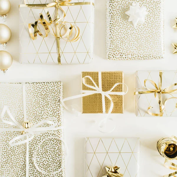礼品盒与弓和金色装饰在白色的背景 圣诞节日公寓 顶视图组成 — 图库照片