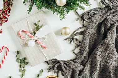 Hediye kutusu dekore edilmiş şeker, okaliptüs, etiketi ile; çelenk çerçeve çam dalları ve kırmızı meyveler yapılmış. Yılbaşı / yeni yıl tatil kompozisyon. Düz yatıyordu, en iyi görünümü.