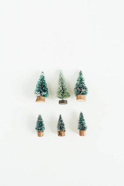Toy fir-trees decoration on white background. Flat lay, top view winter, christmas, new year composition. clipart
