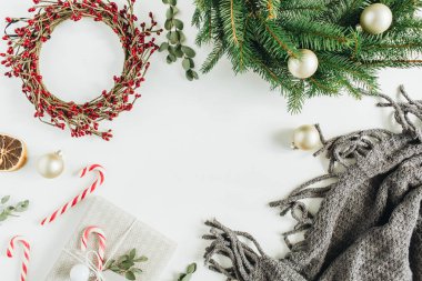 Sahte Noel süslemeleri çerçeve yukarı: çam dalları ve kırmızı meyveler, şeker, battaniye, okaliptüs beyaz zemin üzerine yapılan çelenk çerçeve. Düz yatıyordu, en iyi görünümü.