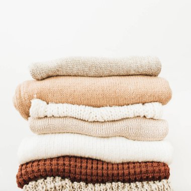 Beyaz arka plan yün kazak ve pullovers yığını. Kadın moda giysileri beyaz arka plan üzerinde.